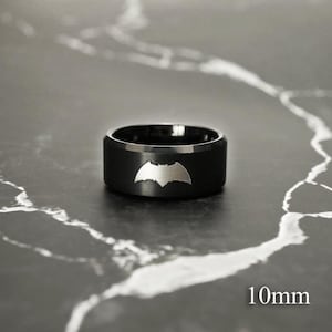 May include: A black ring with a silver Batman logo. The ring is 10mm wide.