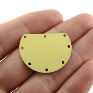 May include: A gold-coloured metal half-circle with eight evenly spaced holes around the edge.