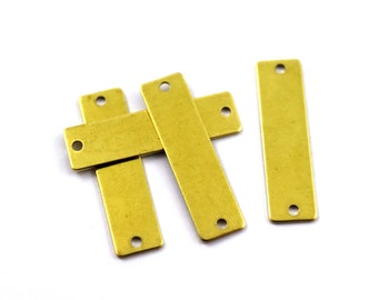 May include: Four brass rectangular tags with two holes each. The tags are stacked on top of each other.