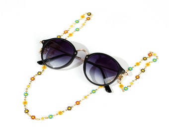 May include: Black round sunglasses with a gold chain featuring colorful daisy-shaped beads.
