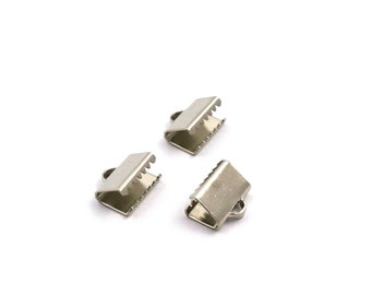 Op de afbeelding: Drie zilveren metalen sluitingen voor het maken van sieraden. De sluitingen zijn klein en hebben een rechthoekige vorm met een kleine lus aan één kant.