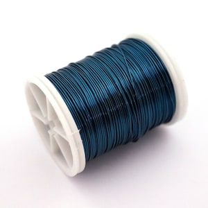 May include: A spool of teal blue wire on a white plastic spool.