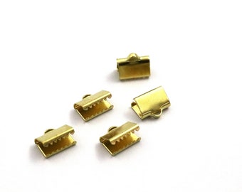 May include: Five gold-colored metal clasps for jewelry making. The clasps are rectangular with a small loop on one end.