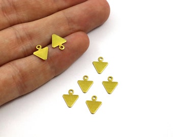 May include: A set of eight gold-toned triangle charms with a loop at the top. The charms are arranged on a white surface.