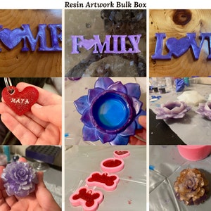 May include: A bulk box of resin artwork featuring various designs, including a purple "HOME" sign, a purple "FAMILY" sign, a purple "LOVE" sign, a purple flower with a blue center, a red heart with the name "MAYA" inscribed, a purple rose, and a gold rose.