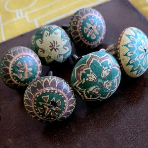 Puede incluir: Seis pomos de madera verde y marr&oacute;n con intrincados dise&ntilde;os florales. Los pomos tienen un acabado desgastado y son perfectos para agregar un toque de encanto vintage a cualquier proyecto de decoraci&oacute;n del hogar.