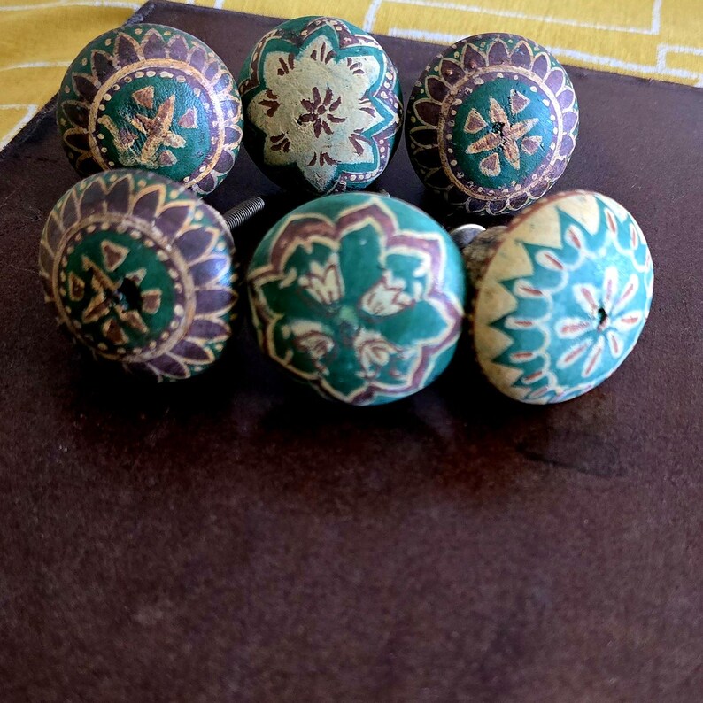 Puede incluir: Seis pomos de cer&aacute;mica pintados en verde y marr&oacute;n con intrincados dise&ntilde;os florales. Los pomos tienen un aspecto desgastado y son perfectos para a&ntilde;adir un toque de encanto vintage a cualquier proyecto de decoraci&oacute;n del hogar.