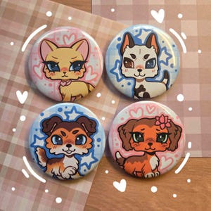 May include: Four circular pin-back badges featuring stylised cartoon animal illustrations. The top left badge shows a tan cat, the top right a white and black dog, the bottom left a brown and white dog, and the bottom right a brown dog with a pink flower.