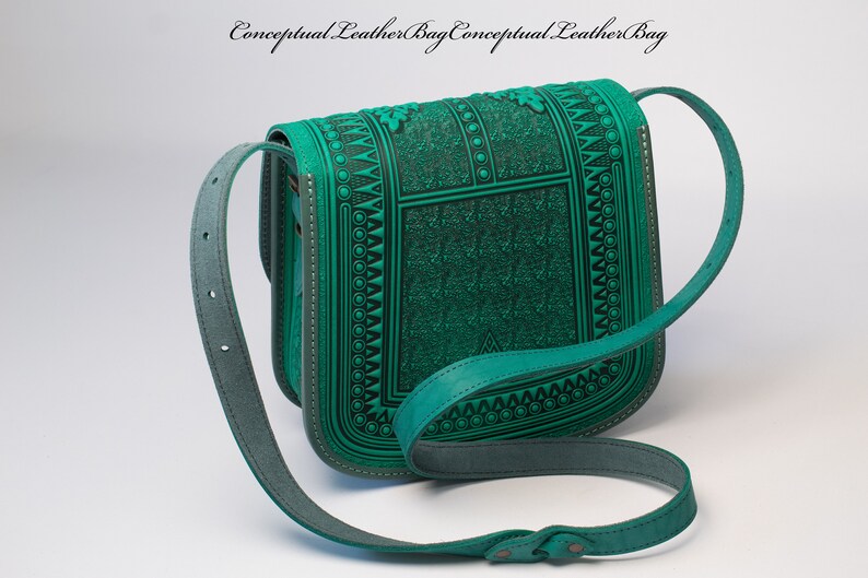 May include: A teal green leather shoulder bag with a geometric pattern and a long adjustable strap.  The bag has a flap closure and a small pocket on the front.