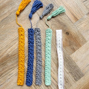 May include: Five crocheted bookmarks with tassels in yellow, blue, gray, green, and a ruler measuring 19 inches.