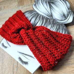 May include: Red crocheted headband with a knotted bow. The headband is made with a chunky yarn and has a speckled texture.
