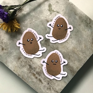 May include: Three brown potato stickers with white outlines and black eyes. Each potato has arms and legs and says "I'm a potato!" in black text.