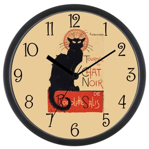 May include: A black and white clock with a black cat illustration on the face. The clock face has a cream background with red and black text that reads "Tournée du Chat Noir de  Rodolphe Salis". The clock hands are black.