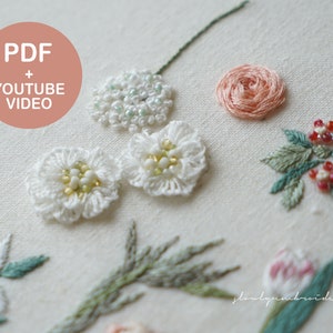 以下が含まれることがあります： クリーム色の生地に刺繍された花のクローズアップ。白、桃色、緑色の手縫いの花がいくつかあり、ビーズのアクセントが付いています。ピンクの円の中のテキストは「PDF + YOUTUBE VIDEO」と書かれています。