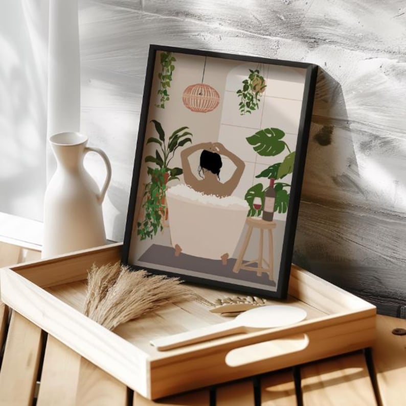 May include: A framed illustration of a person relaxing in a bathtub with bubbles, surrounded by plants and a glass of wine on a stool. The bathroom has a white tiled wall and a wicker light fixture.