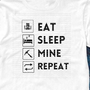 May include: White t-shirt with black text that reads "Eat Sleep Mine Repeat" with icons representing each word. The icons are a plate with a fork and knife, a bed, a pickaxe, and a circular arrow.