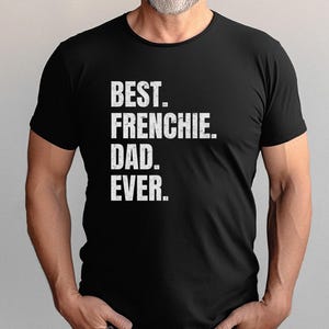 May include: Black t-shirt with the text "BEST. FRENCHIE. DAD. EVER." in a distressed white font. The shirt is a crew neck style and is being worn by a person.