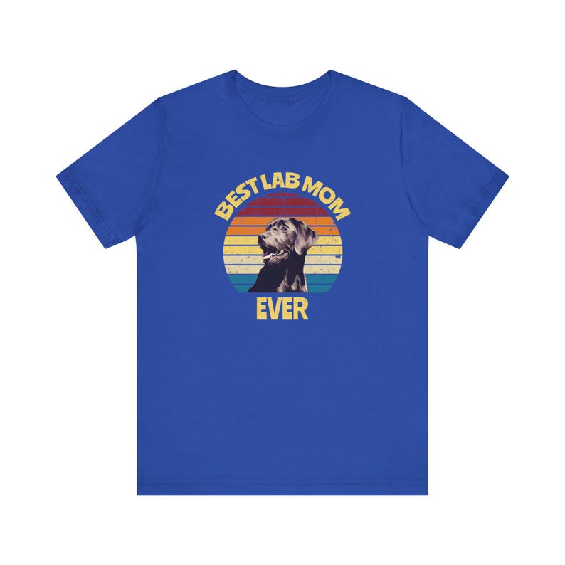 May include: A royal blue short-sleeve t-shirt featuring a graphic print of a Labrador retriever inside a sunset-colored circle. The text BEST LAB MOM EVER is printed in yellow, with BEST LAB MOM arched above the dog and EVER below it.
