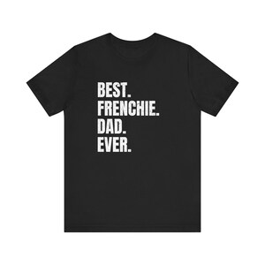 May include: Black t-shirt with white text that reads "BEST. FRENCHIE. DAD. EVER." The shirt is a crew neck style and appears to be made of a soft material. The text is centered on the front of the shirt.