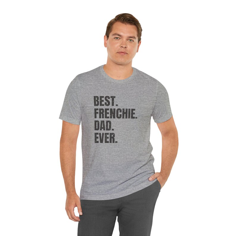 May include: A heather gray t-shirt with the text "BEST. FRENCHIE. DAD. EVER." in black. The shirt is worn by a person, and the overall style is casual and comfortable.