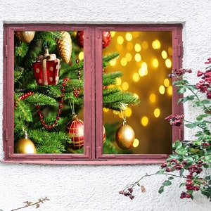 May include: A window with a view of a decorated Christmas tree with red and gold ornaments, red beads, and a red gift box. The tree is lit with warm white lights. The window is framed in red wood and is surrounded by a white wall.