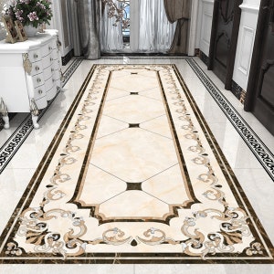 May include: A beige and brown patterned runner rug with a black border. The rug has a geometric design with a floral pattern.