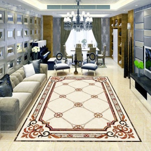 May include: A white and beige patterned tile rug with a red and brown border. The rug has a geometric design with a floral motif. The rug is in a living room setting with a couch and chairs.