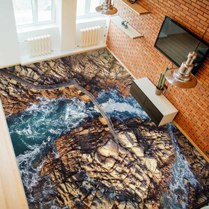 May include: A 3D floor covering featuring a realistic image of a rocky coastline with crashing waves and a wooden walkway.