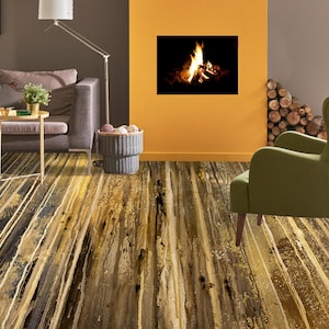 Może przedstawiać: Salon z kominkiem, sofą i fotelem. W kominku pali się ogień. Sofa jest szara, a fotel zielony. Podłoga jest wykonana z drewnianych desek.