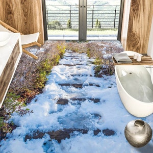 Puede incluir: Un baño con un camino de piedra nevado que conduce a una bañera blanca. El baño tiene un tocador de madera con dos lavabos y una ventana con vista a un paisaje verde.