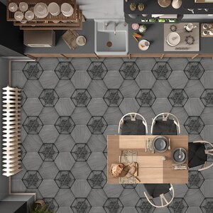 May include: A top-down view of a dining room with a wooden table and chairs. The table is set with a placemat, a plate, and silverware. The floor is tiled with hexagonal tiles in a gray and black pattern.
