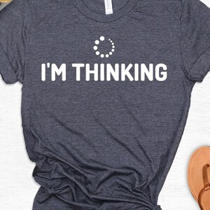 May include: A dark blue t-shirt with a white loading icon and the text "I'M THINKING".