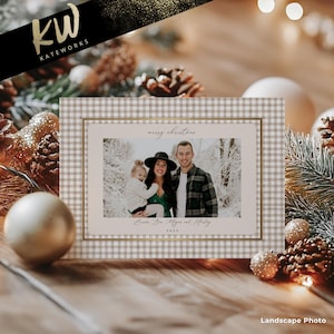 May include: A framed family photo with a gingham pattern border. The photo features a family of three in a snowy outdoor setting. The words "merry christmas" and family names are written on the photo. The year 2023 is also written on the photo.