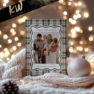 May include: A Christmas card with a family photo inside a decorative frame. The frame is set against a green and red plaid background. The card reads "Merry Christmas" and includes the family's names.