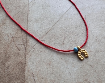 Ketting met hoefijzerhanger, minimalistische gouden hanger aan een rood koord, gelukbrengend sieraad voor elke dag