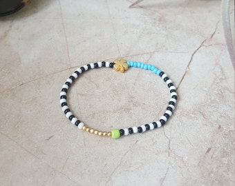 Gestreepte kralenarmband: 14k gouden klavertjebedel, handgemaakte stretchsieraden