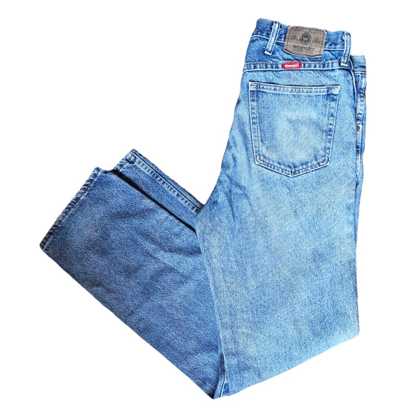 May include: A pair of blue denim jeans with a Wrangler label on the back pocket.