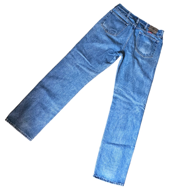 May include: A pair of blue denim jeans with a faded look. The jeans have a straight leg and a classic five-pocket design.