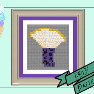 Puede incluir: Un patrón de punto de cruz enmarcado que presenta una flor estilizada con una parte superior en forma de abanico amarilla y blanca y una base morada moteada de negro. El fondo es gris y el marco es dorado. El texto "PDF PATTERN" está en una pancarta verde.