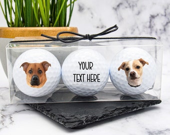 May include: Three white golf balls with personalized dog photos. The center ball has the text "YOUR TEXT HERE".
