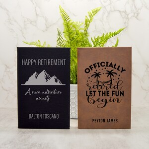 May include: Two personalised leather journals with engraved text. The black journal has a mountain design and the text "HAPPY RETIREMENT A new adventure awaits DALTON TOSCANO". The brown journal has a palm tree design and the text "OFFICIALLY retired LET THE FUN begin PEYTON JAMES".