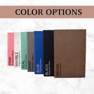 May include: A display of color options for a product, featuring a row of notebooks in various colors: pink, marble, teal, gray, blue, black, and brown. Each notebook has text indicating the color and engraving color. The text "COLOR OPTIONS" is at the top.