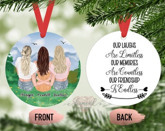 May include: A round, white bauble with the text "OUR LAUGHS Are Limitless OUR MEMORIES Are Countless OUR FRIENDSHIP ... Is Endless..." The bauble is decorated with a leafy branch and two hearts. The back of the bauble features a painted image of three women standing together in a green field with mountains in the background. The women's names are written below them: Meagan, Fendell, and Heather.