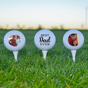 May include: Three white golf balls with personalized photos and text. The middle ball has the text "BEST Dad EVER".