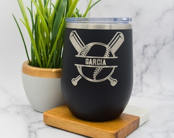 May include: Black stainless steel tumbler with a baseball and crossed bats design. The name "Garcia" is engraved on the tumbler.