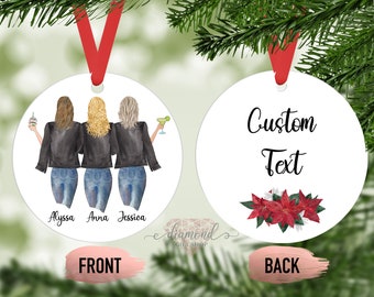May include: A white round Christmas ornament with a watercolor illustration of three women wearing denim jackets and jeans. The ornament has the names Alyssa, Anna, and Jessica written below the women. The back of the ornament is white with the words "Custom Text" and a red poinsettia flower.