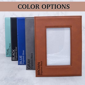 May include: Five leather picture frames in different colors: teal, black, blue, gray, and brown. Each frame has a white mat and a black stitched border. The text on each frame indicates the color and whether it engraves in black or silver.