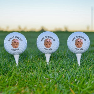 Pu&ograve; includere: Tre palline da golf bianche con il viso di un bambino e il testo "HAPPY 1ST FATHER'S DAY I LOVE YOU" su ogni pallina.