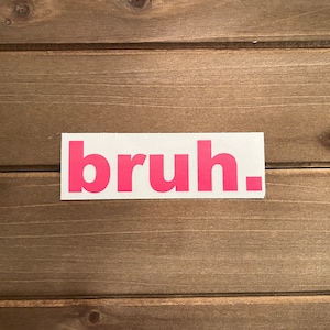 May include: A white sticker with the word "bruh" printed in pink letters.