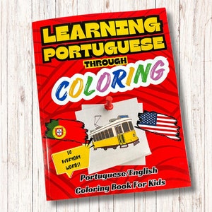 May include: A red book with the title "Learning Portuguese Through Coloring" and a picture of a yellow tram. The book includes 50 everyday words in Portuguese and English.